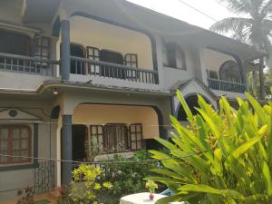 a house with balconies and plants in front of it at Koito-House calangute guest house in Calangute