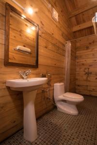 a wooden bathroom with a sink and a toilet at Dreams Hostel in Vagator