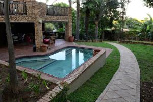 a swimming pool in a yard next to a house at 250onIndus in Pretoria