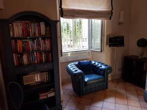 a living room with a blue chair and a book shelf at Hotel Kennedy in Rome