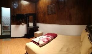 a bedroom with a bed and a tv in it at Dieng Plateau Guest House in Diyeng