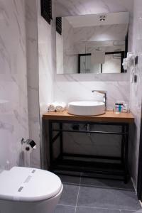 Meydan Besiktas Hotel في إسطنبول: حمام مع حوض ومرحاض ومرآة