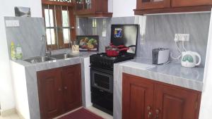 a small kitchen with a stove and a sink at Nethmi Villa in Bentota +13 photos
