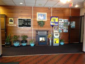 an atm machine in a lobby with potted plants at Moby Dick Inn in Prince Rupert