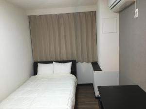 a small bedroom with a bed and a window at TIMES INN 2F in Tokyo