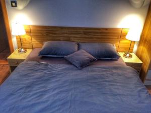 a bed with two blue pillows in a bedroom at KOP Centar Aviator in Kopaonik