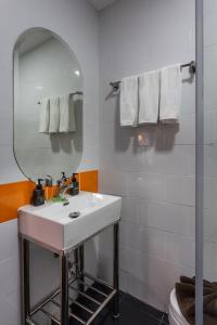 a bathroom with a sink, mirror, and towel rack at 7 Days Premium Hotel Pattaya - SHA Extra Plus in Pattaya South