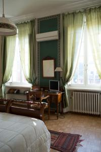 a bedroom with a bed and a desk with a computer at Palazzo Arrivabene B&B in Mantova