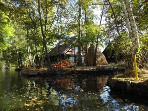 a house on the bank of a river with boats at Ferienhaus Lagenhof! Keine Monteure! in Gablenz