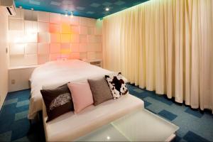 a bedroom with a bed with pillows on it at HOTEL LYISTA (Adult Only) in Hanamaki