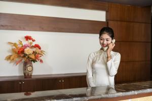 uma mulher a falar ao telemóvel em The Sunriver Boutique Hotel Hue em Hue