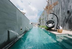 a swimming pool with a fountain in the middle of a building at Lloyd's Inn Bali in Seminyak