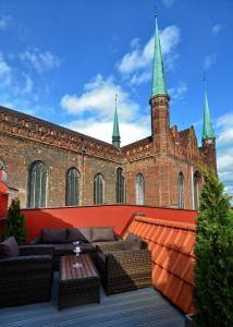 a patio with couches and tables in front of a building at Stay inn Hotel Gdańsk in Gdańsk