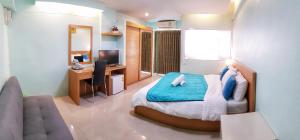 a bedroom with a bed and a desk with a computer at J.Residence in Samut Prakan
