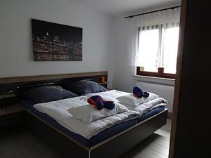 a bedroom with a bed with blue shoes on it at Ferienhaus Lagenhof! Keine Monteure! in Gablenz +32 photos