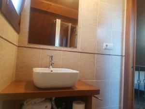 Un baño con un lavabo blanco y un espejo. en Casa Da Chousa, en Combarro
