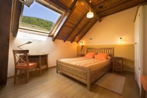 a bedroom with a bed and a desk and a window at Hotel Rural Besaro - Selva de Irati in Izalzu