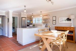 a kitchen with a wooden table and chairs at 33 Strawberry Lane - Studio and Cottage in Cape Town