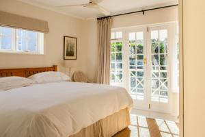 a bedroom with a bed and a large window at 33 Strawberry Lane - Studio and Cottage in Cape Town