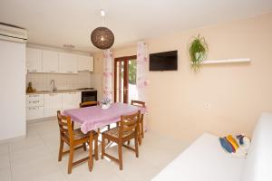 a kitchen and dining room with a table and chairs at Lovely apartments Balić in Ivan Dolac
