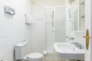 a white bathroom with a toilet and a sink at La Fenice in Prague