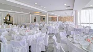 a banquet hall with white tables and white chairs at Hotel Adriatic in Dubrovnik