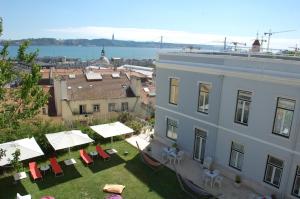 Lisb'on Hostel في لشبونة: اطلالة على مبنى به ساحة بها طاولات وكراسي