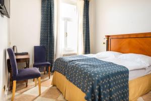 a bedroom with a bed and a desk and a window at La Fenice in Prague