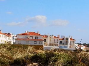 un groupe de maisons au sommet d'une plage dans l'établissement LAJINHA MAR-BEACH APARTMENT-Zambujeira Mar, à Zambujeira do Mar