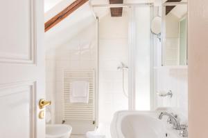 a white bathroom with a shower and a sink at La Fenice in Prague