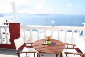 a table on a balcony with a view of the ocean at Maryloujohn Villas Oia in Oia