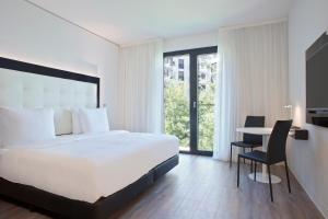 a hotel room with a bed, chair, and table at INNSiDE by Meliá Frankfurt Ostend in Frankfurt