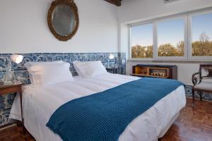 リスボンにあるCastilho Luxのベッドルーム(青と白のベッド1台、窓付)