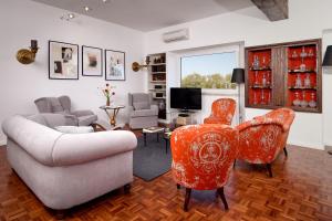 リスボンにあるCastilho Luxのリビングルーム(ソファ、椅子、テレビ付)