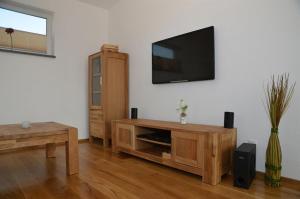 a living room with a flat screen tv on a wall at erholBAR in Eckfeld