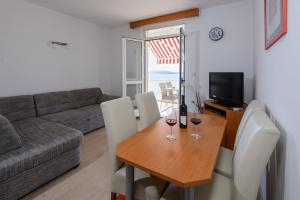 ein Wohnzimmer mit einem Tisch und 2 Gläsern Wein in der Unterkunft Sunset Apartment in Zaton