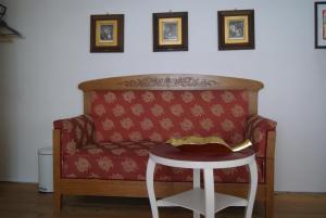 eine rote Couch mit einem Tisch in einem Zimmer in der Unterkunft Zweite Heimat Privatpension in Landsberg am Lech