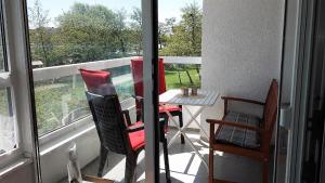 クックスハーフェンにあるFrische Brise 01.03のバルコニー(テーブル、椅子付)、窓が備わります。