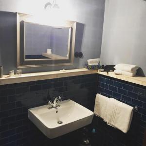 La salle de bains est pourvue d'un lavabo blanc et d'un miroir. dans l'établissement Landhotel Ruhepol - garni, à Arnstadt