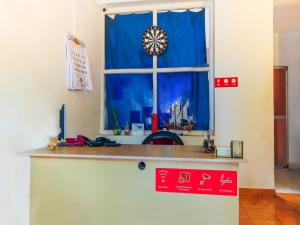 a kitchen counter with a window with a blue curtain at Sea View Holiday Vagator in Vagator