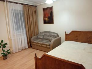 a bedroom with a bed and a couch and a chair at Holiday Park Russkaya Usadba in Zabor'ye