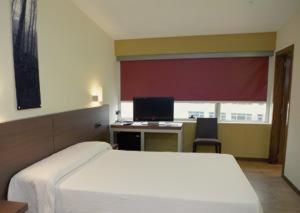 1 dormitorio con 1 cama y escritorio con ordenador en Hotel Izelai, en Alsasua