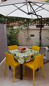 ローマにあるLa Casetta di Elyのテーブルと椅子、テーブルとパラソル付