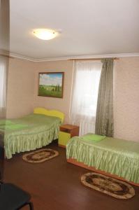 a hotel room with two beds and a window at Holiday Park Russkaya Usadba in Zabor'ye