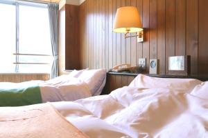 Postel nebo postele na pokoji v ubytování Sora no Mori Hotel Hanagori