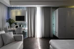 a bedroom with a bed and a living room with a couch at A Point Porto Ercole Resort & Spa in Porto Ercole