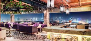 杜拜的住宿－克里克高地凱悅公寓式酒店，一间设有紫色椅子的餐厅,享有城市美景
