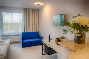 a living room with a blue chair and a table in a room at Mielno Holiday Apartments in Mielno