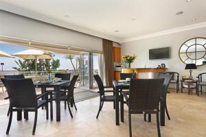a dining room with a table and chairs and a kitchen at Vetho House in Ballito