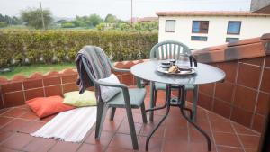 two chairs and a table on a patio at Ak-55 Rural House in Villaviciosa